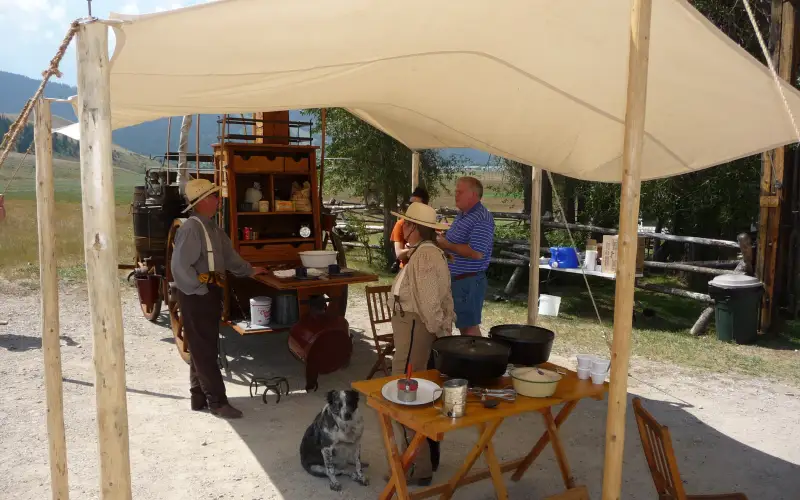 Chuckwagon cooks and cast-iron Dutch ovens under a canvas fly during a cooking demonstration on the National Elk Refuge in Wyoming